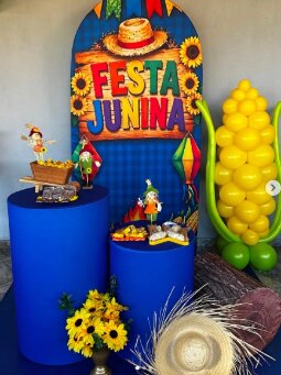 Decoração de Festa Junina com painel colorido, balões amarelos e mesa de doces